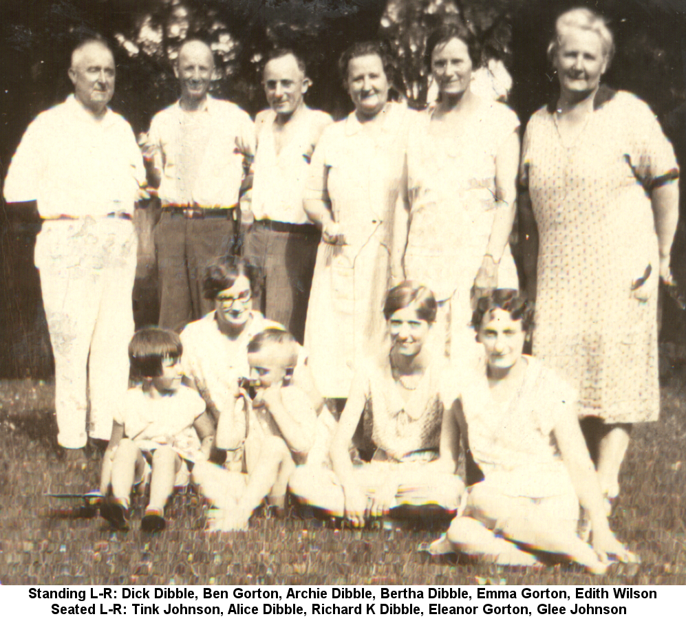 Black and white outdoor photo of men, women and children in summer clothing. Standing left to right: Richard 'Dick' Dibble, Ben Gorton, Archie Dibble, Bertha Kowitz Dibble, Emma Kowitz Gorton, Edith Kowitz Wilson; seated left to right: Shirley 'Tink' Johnson, Alice Dibble, Richard Kenneth Dibble, Eleanor Gorton, Glee Dibble Johnson.